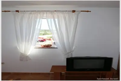 TV i/ili zabavni centar u objektu Apartments Juras - Studio Apartment with Balcony and Side Sea View Tea