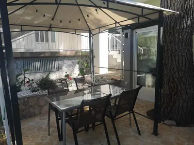 Popločani dio dvorišta ili vanjski dio objekta Mala kuća ispod borova